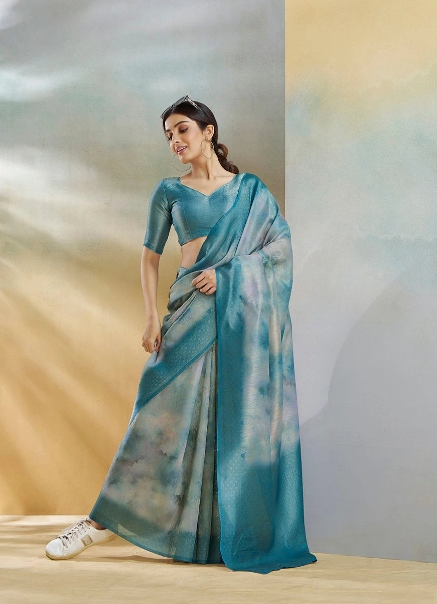 Woman wearing a blue saree with a gradient effect against a neutral background