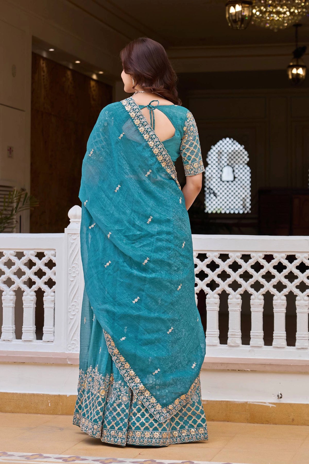 Woman wearing a blue saree with a white background