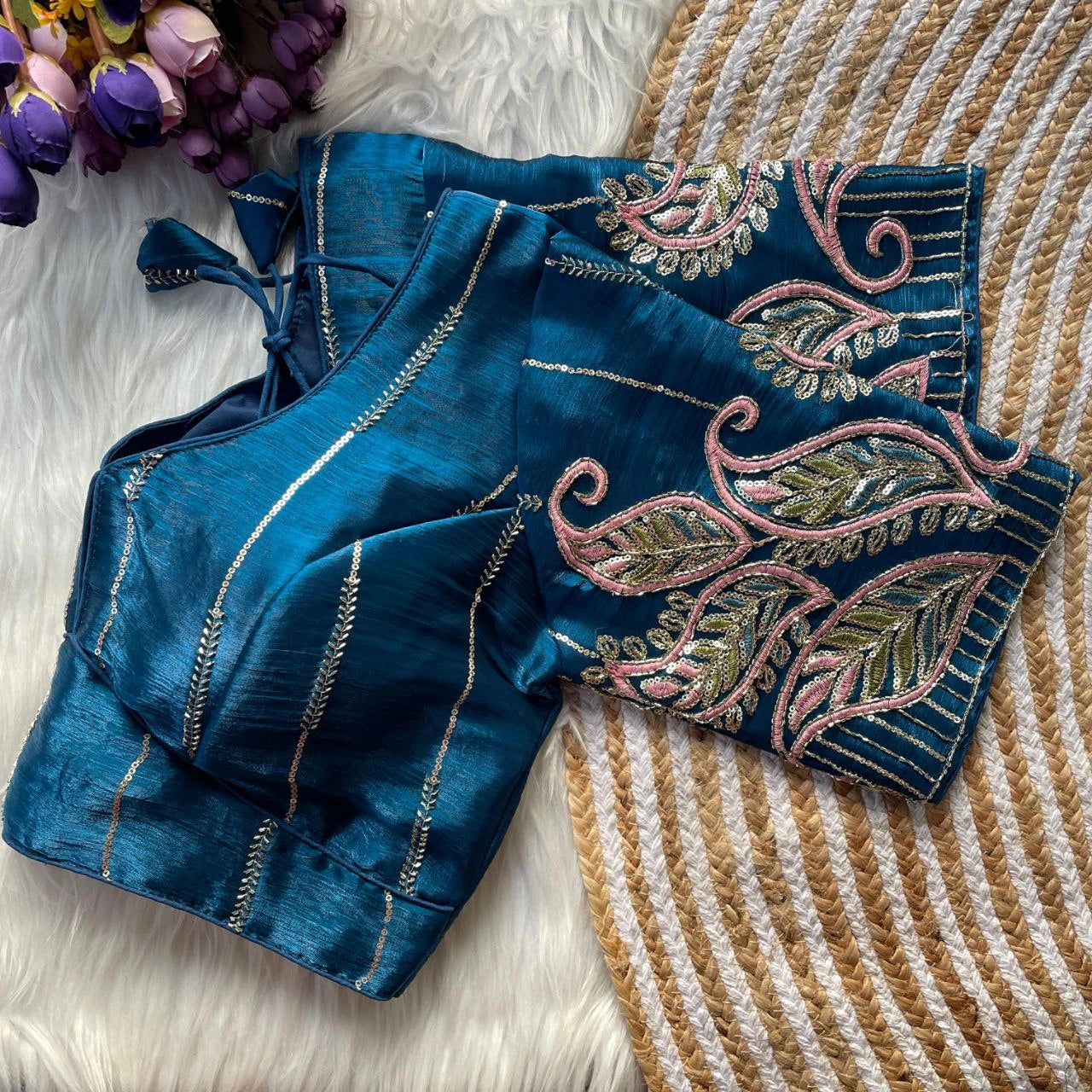 Blue embroidered fabric with floral patterns on a textured surface
