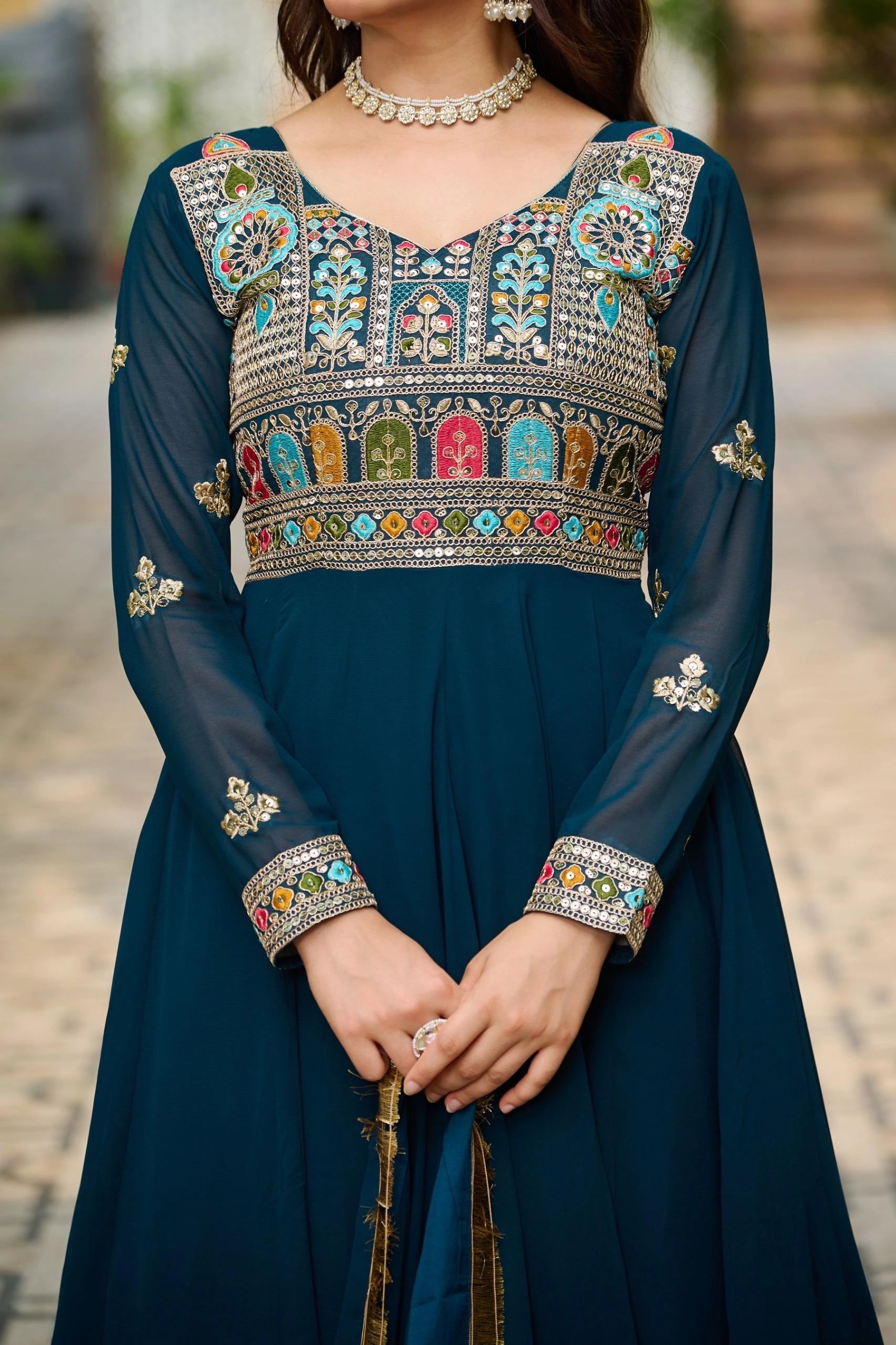 Navy blue traditional outfit with colorful embroidery on a blurred outdoor background