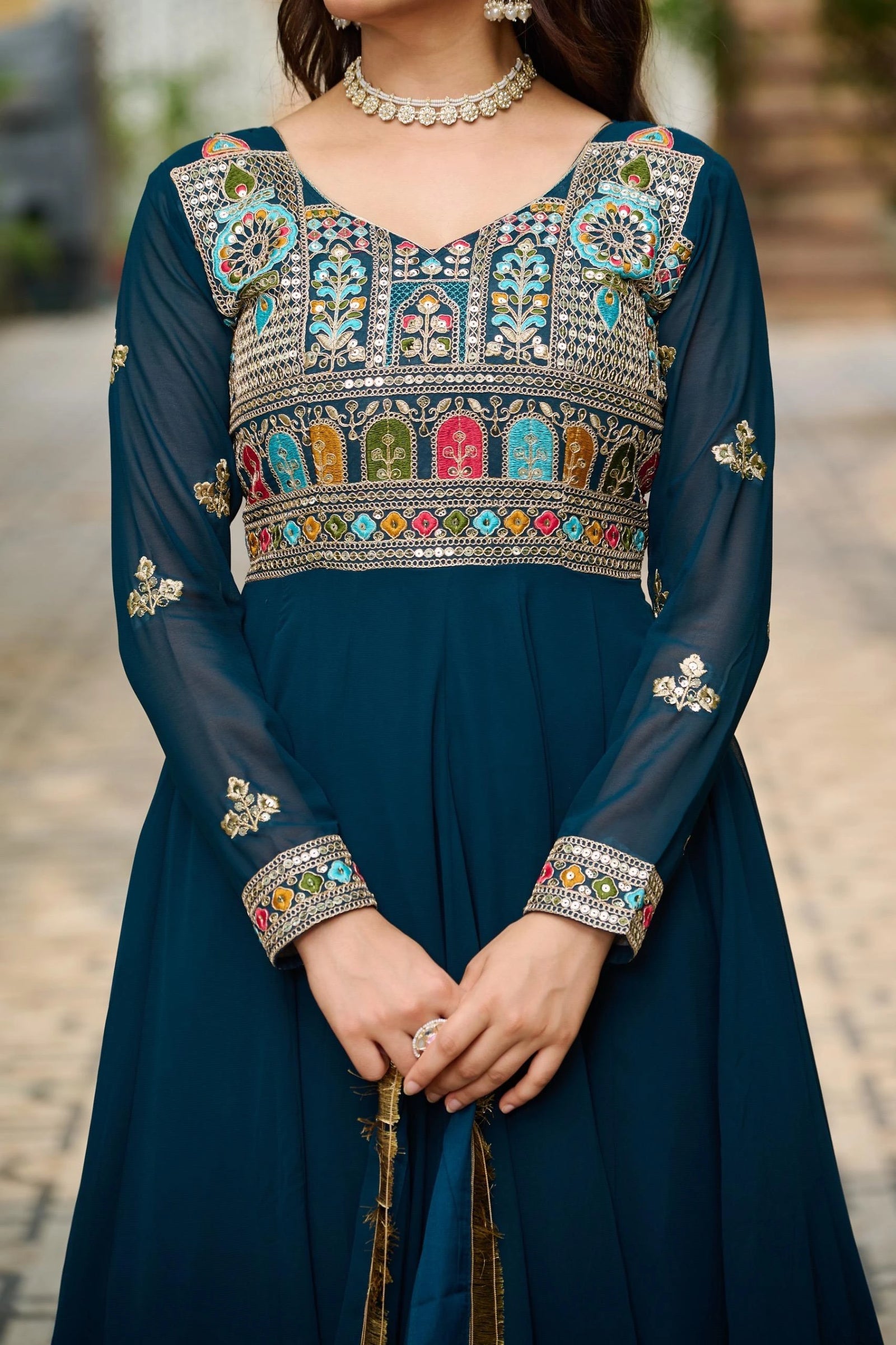 Navy blue traditional outfit with colorful embroidery on a blurred outdoor background