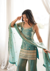 Woman wearing a traditional outfit with a green dupatta in a bright room.