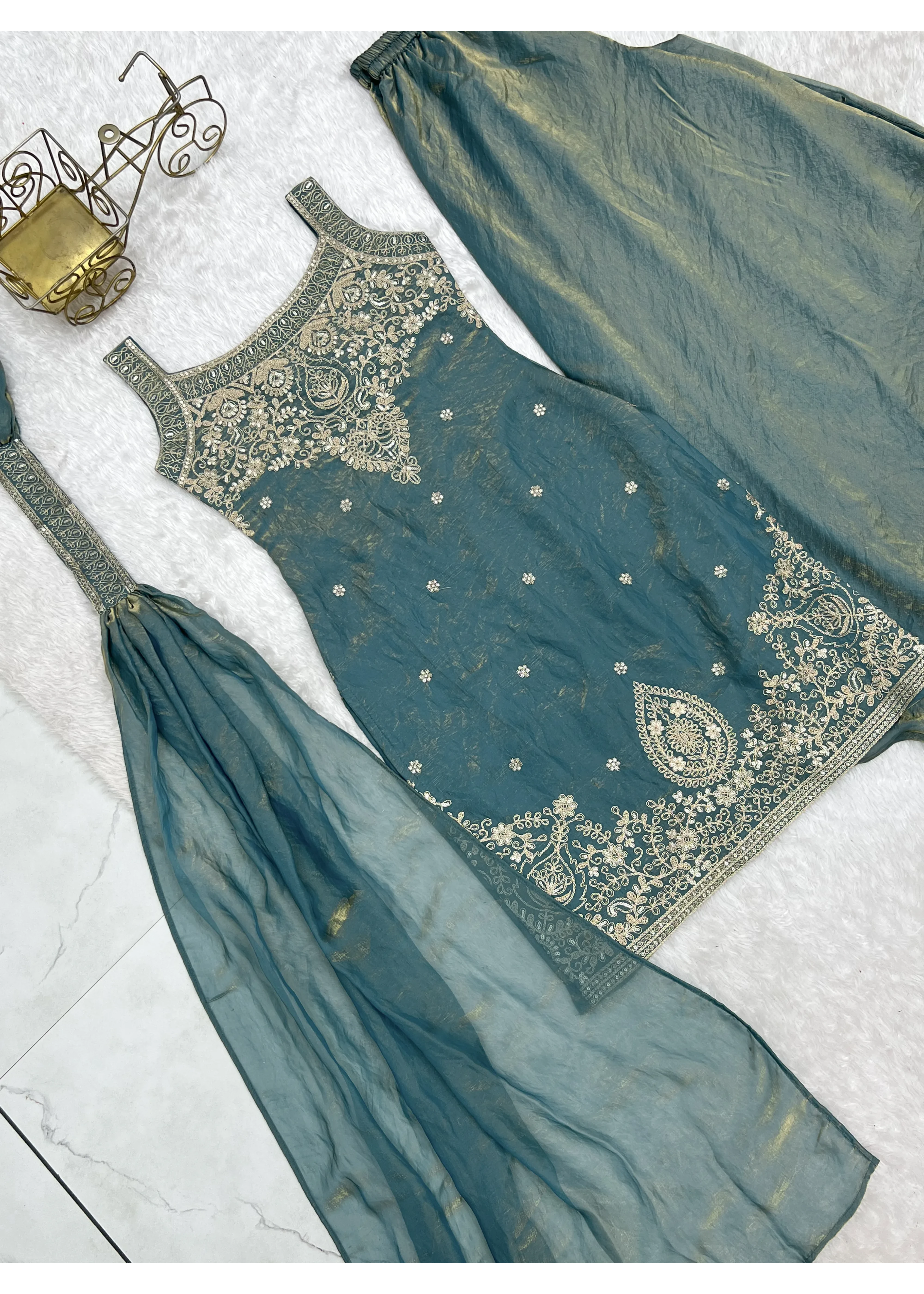 Teal traditional outfit with gold embroidery on a light gray background