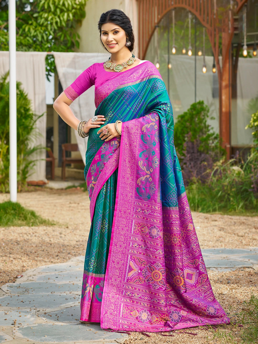 Woman wearing a colorful saree with a patterned design outdoors.