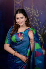 Woman in a colorful saree with jewelry against a dark background