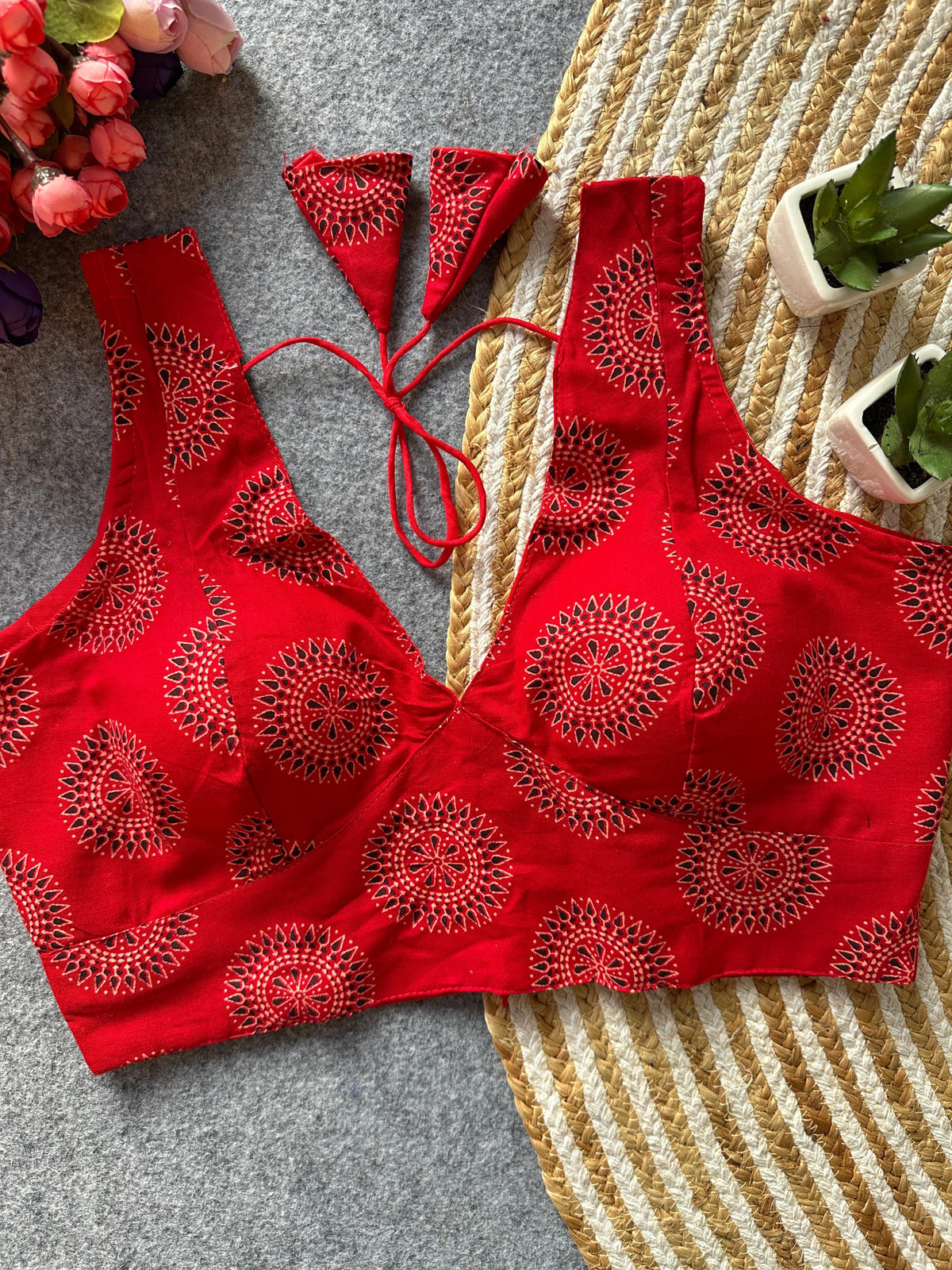 Red bikini set with intricate patterns on a textured surface