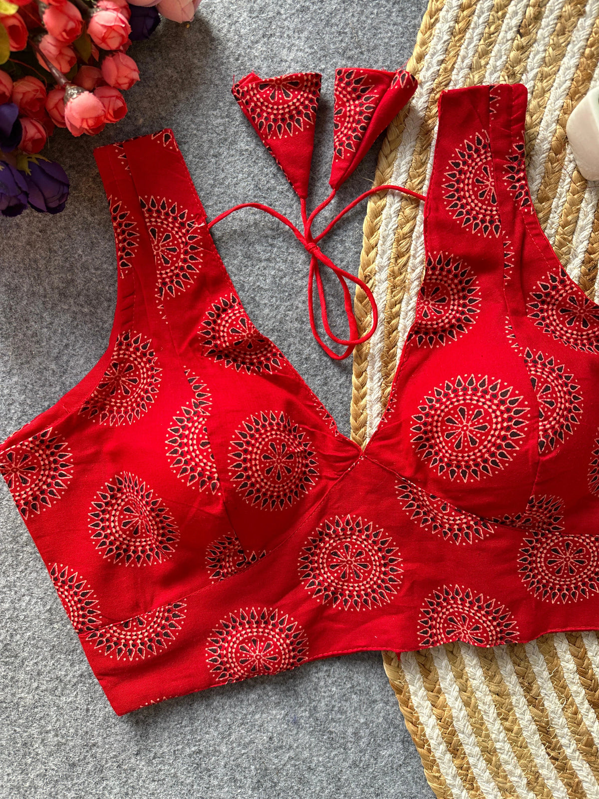 Red bikini set with intricate patterns on a textured surface