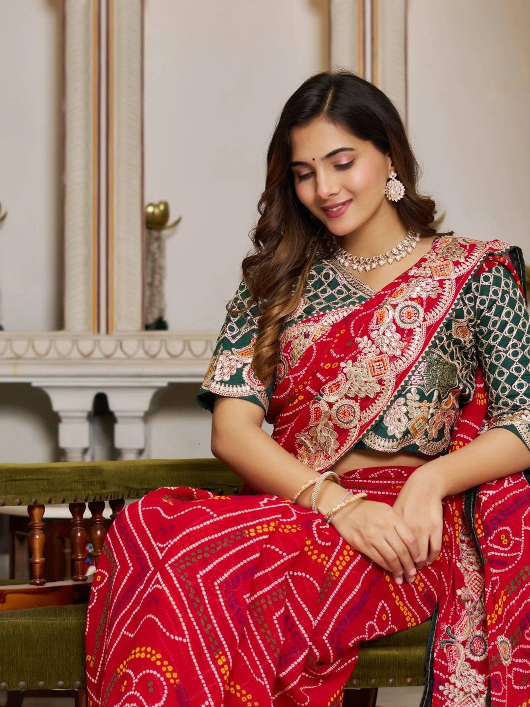 Woman wearing a traditional saree with intricate patterns in a formal setting.