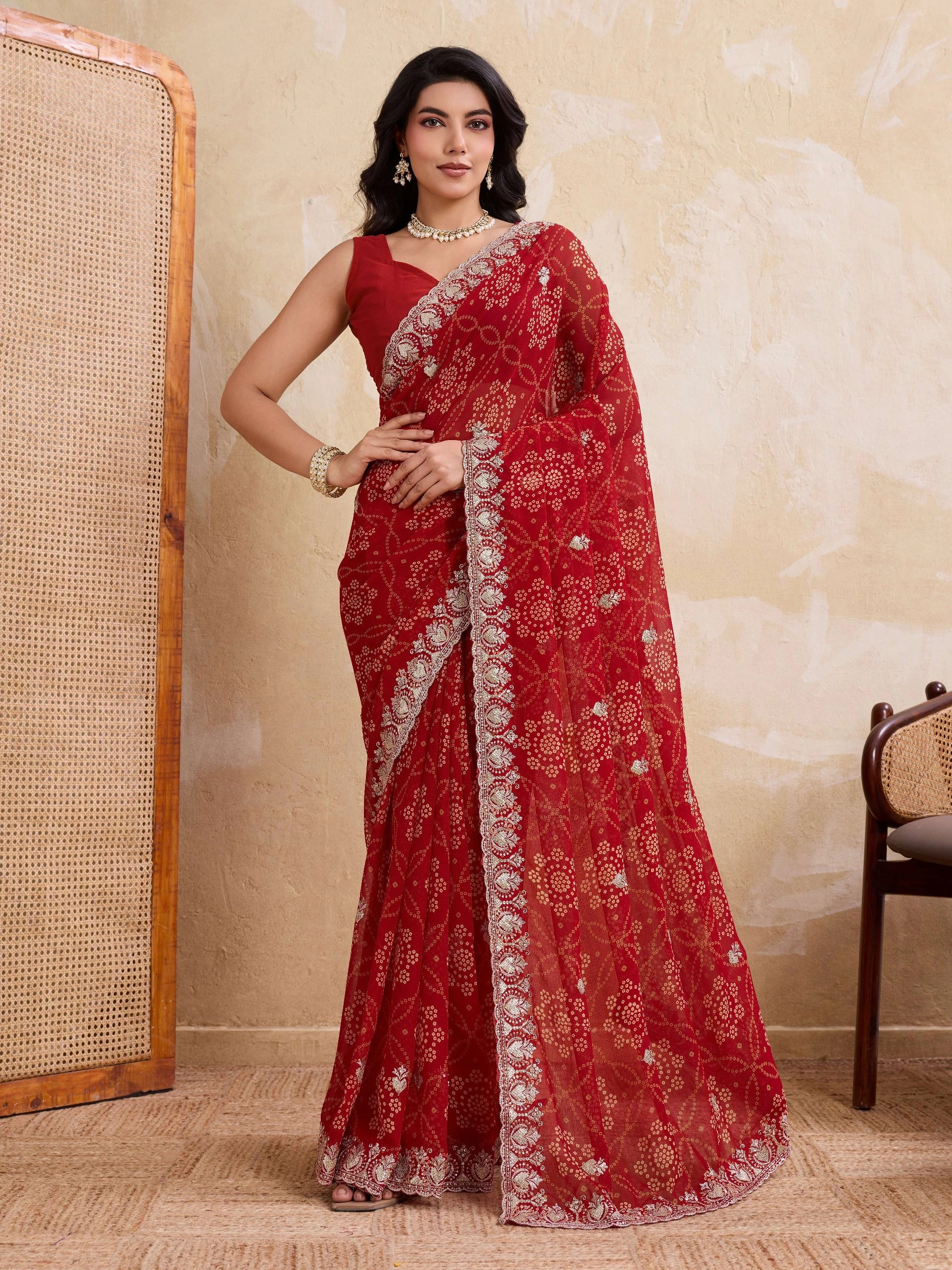 Woman wearing a red saree with white embroidery in an indoor setting