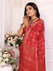 Woman wearing a red saree with floral decorations and flowers in the background