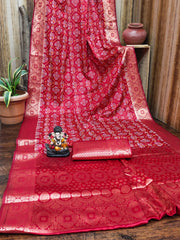 Red patterned fabric with a small statue on a wooden surface