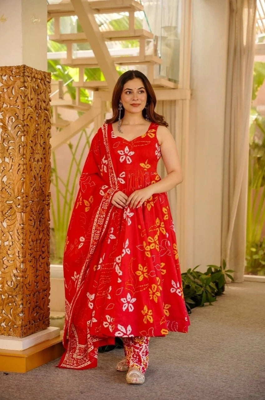 Woman in a red floral dress standing indoors with decorative elements.