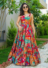 Woman wearing a colorful patterned dress standing outdoors with greenery in the background