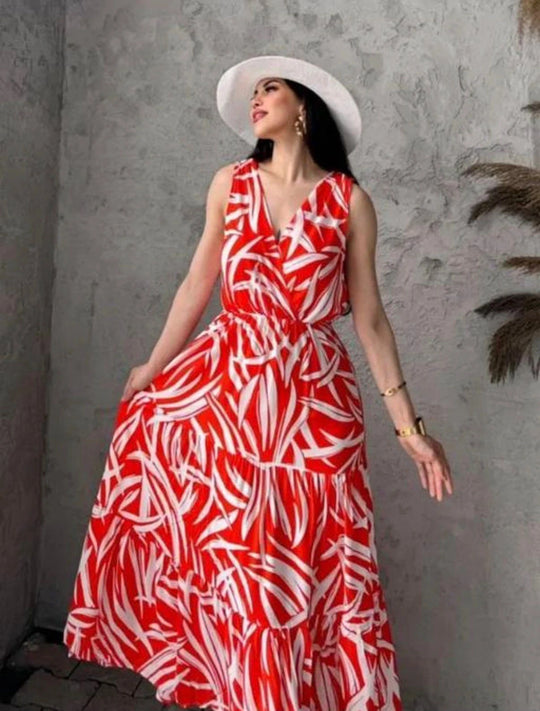 Woman wearing a red and white patterned dress against a gray wall.