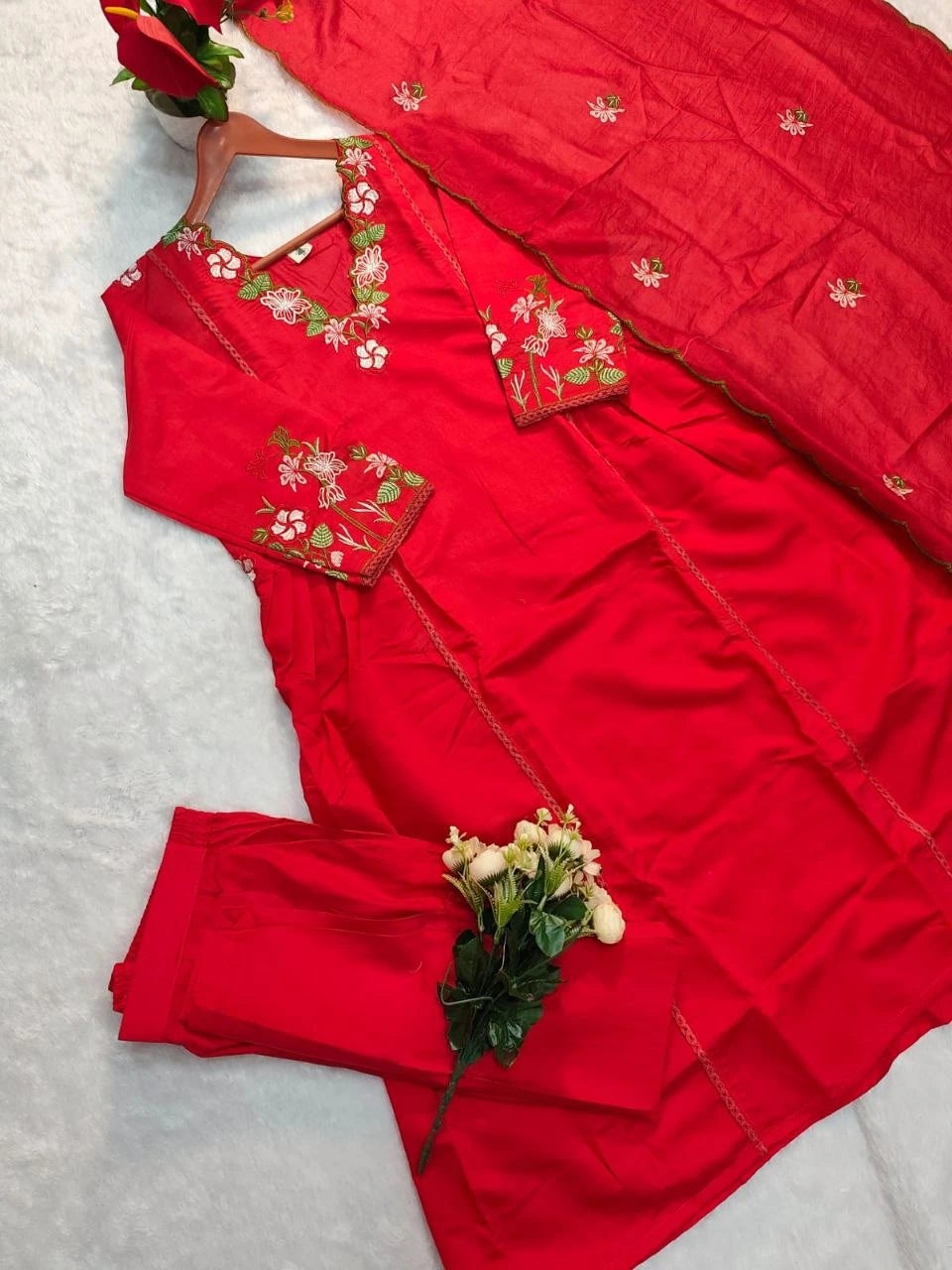 Red embroidered outfit with flowers on a light gray background
