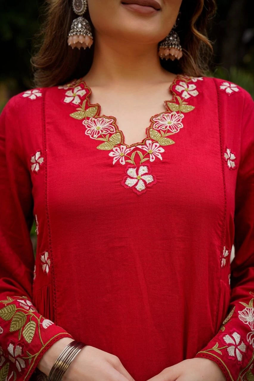 Red embroidered top with floral patterns on a blurred background