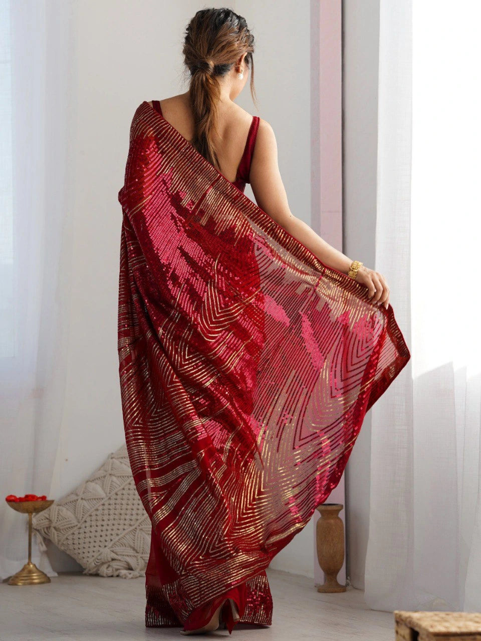 Woman wearing a red saree with a white background