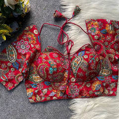 Red embroidered traditional outfit on a textured surface with flowers in the background