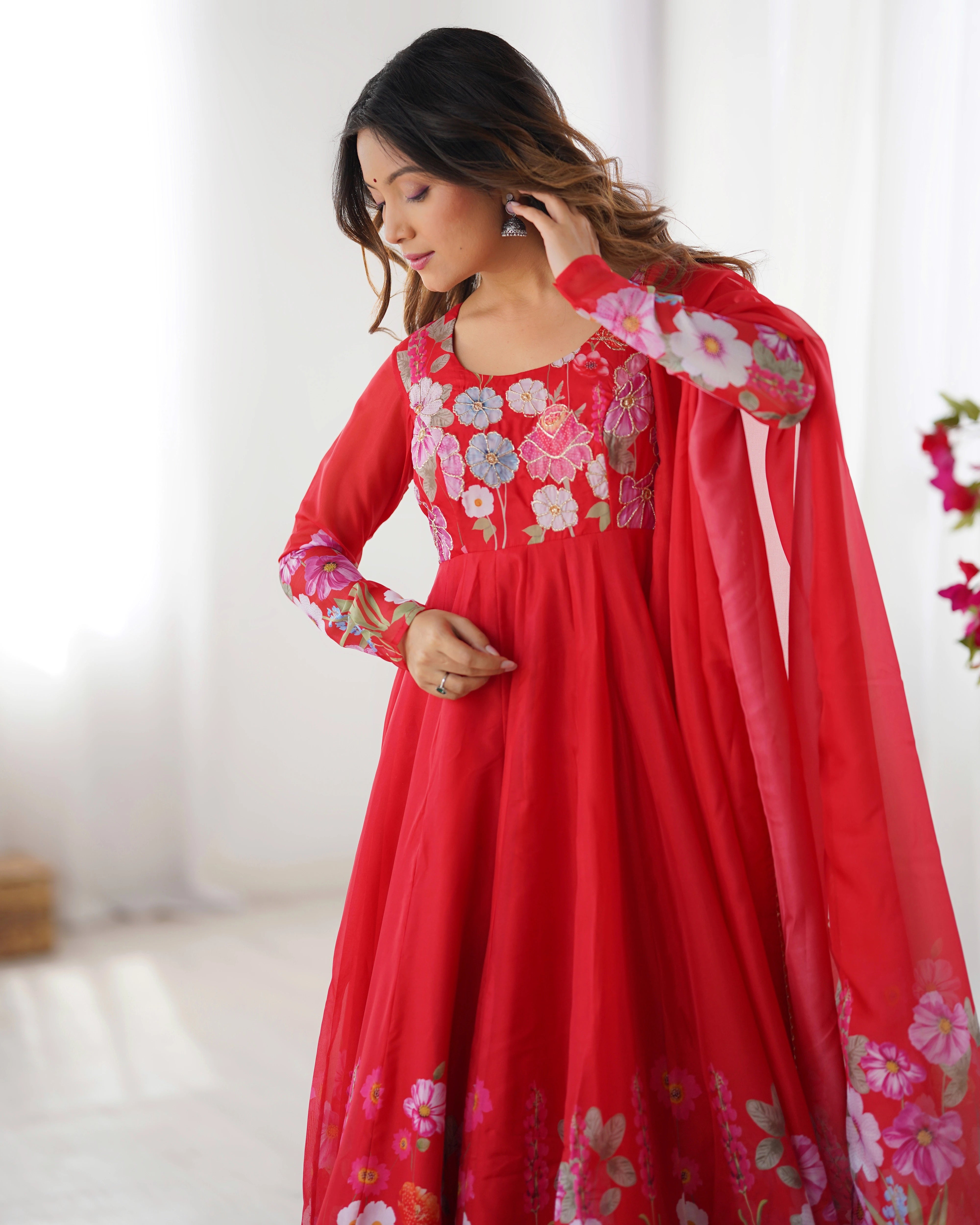 Woman wearing a red floral dress with a white background