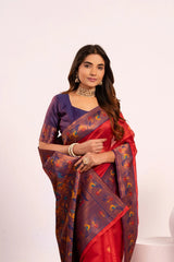 Woman wearing a red and purple saree with intricate patterns on a white background