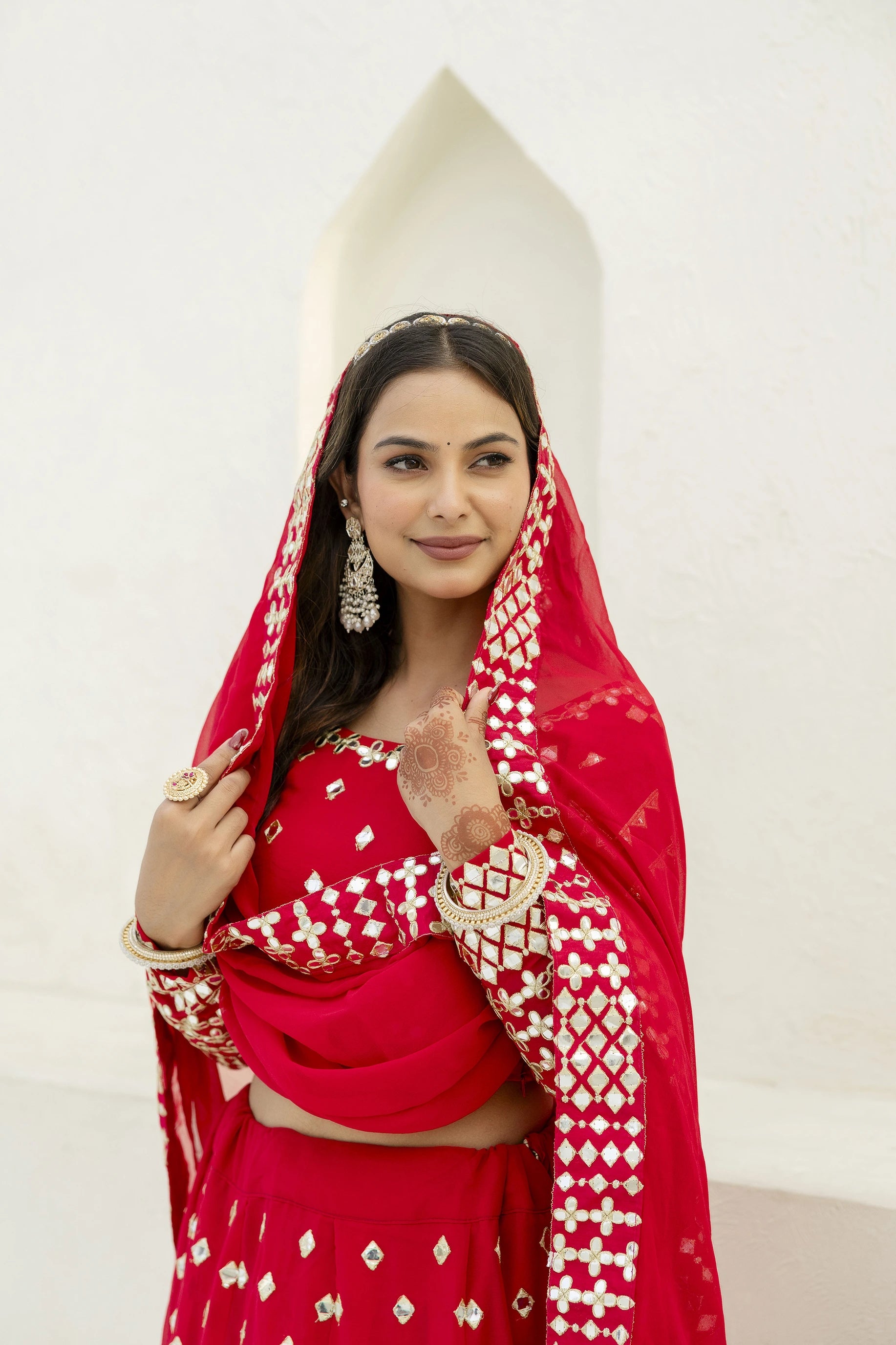 Woman in a red traditional outfit with gold details on a white background