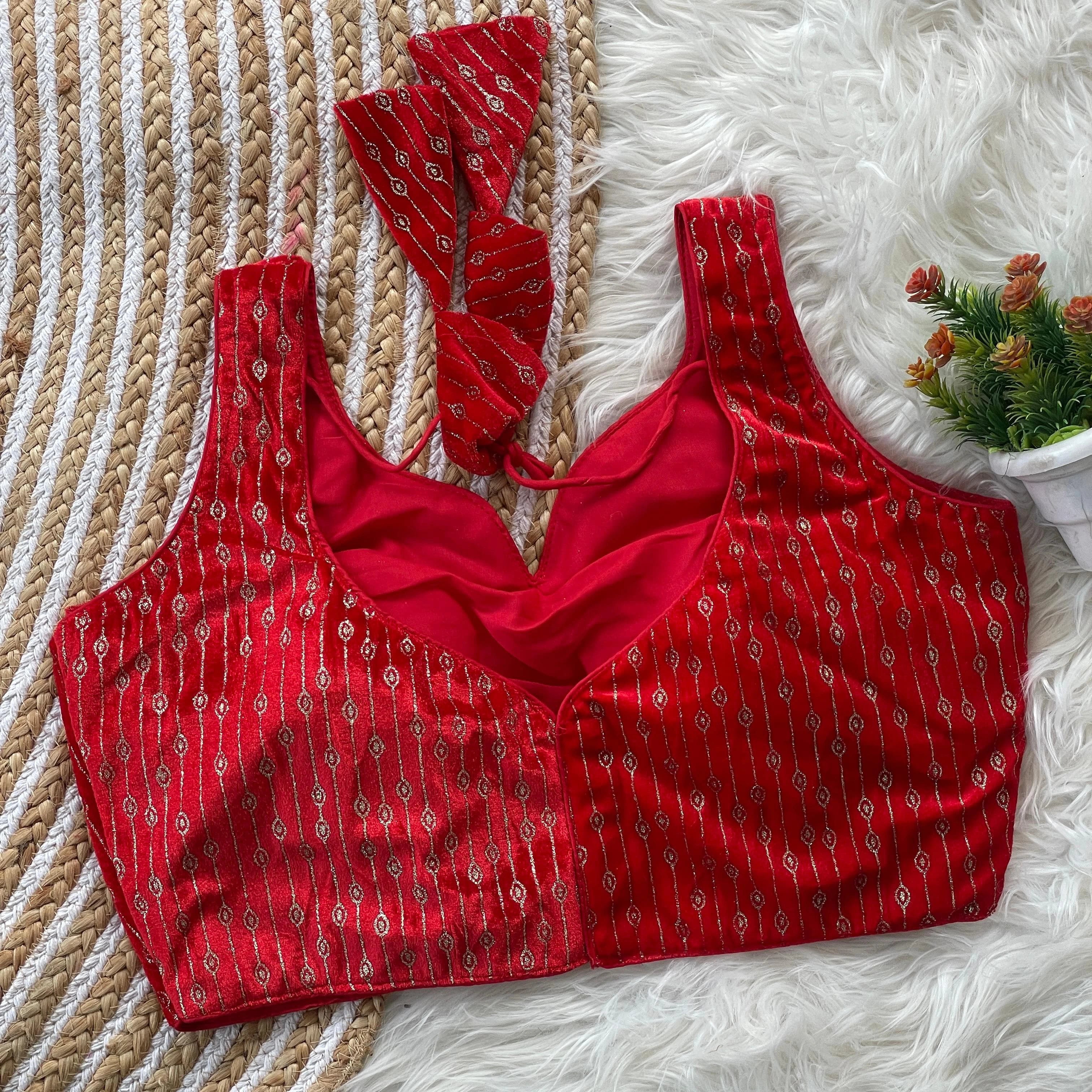 Red patterned top on a textured surface with a small plant.