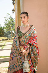 Woman in a traditional saree with a decorative bag outdoors.