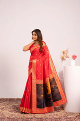 Woman wearing a red saree with gold and black patterns on a white background