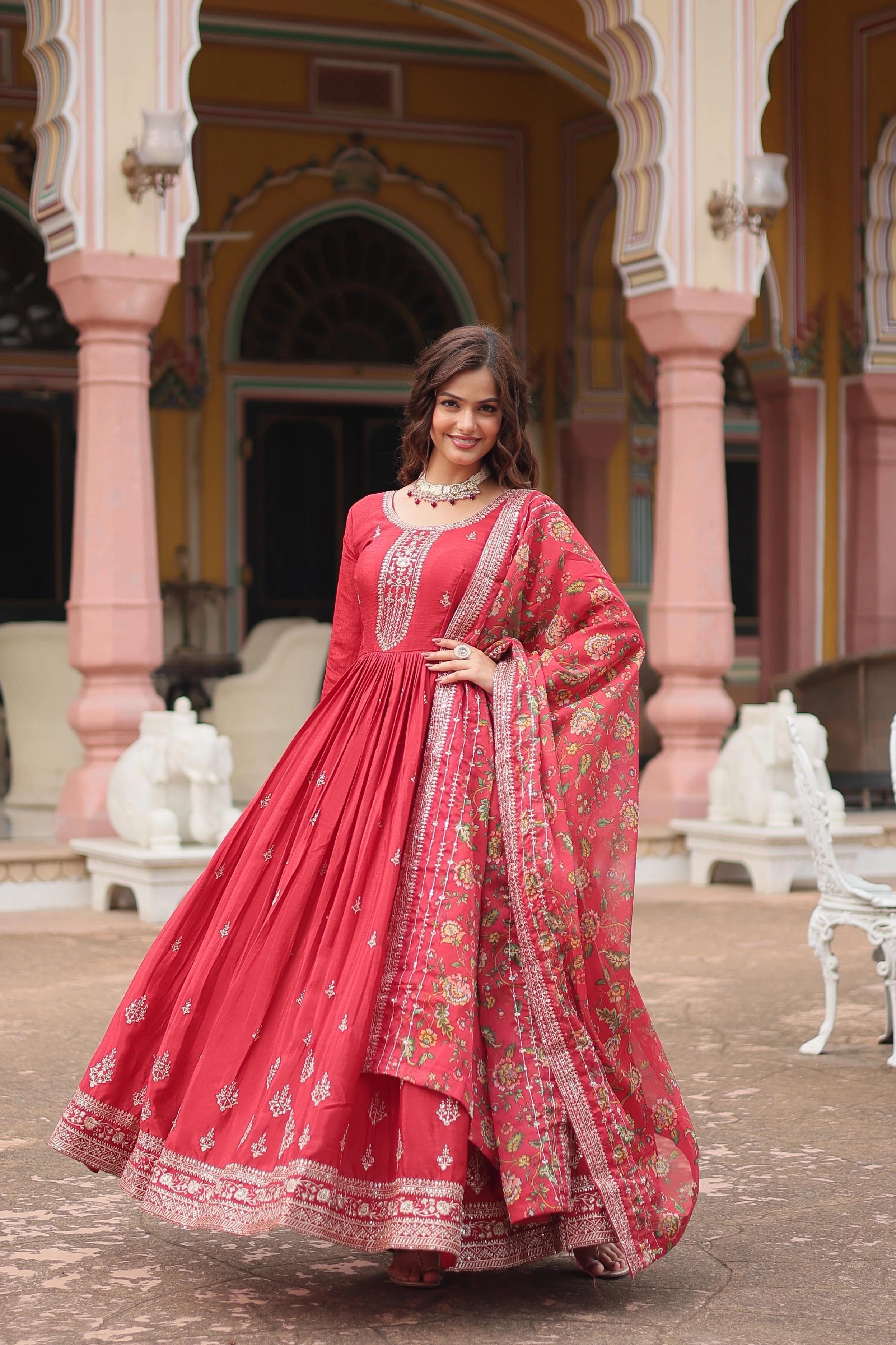 Woman in a red traditional outfit standing in front of an ornate building.