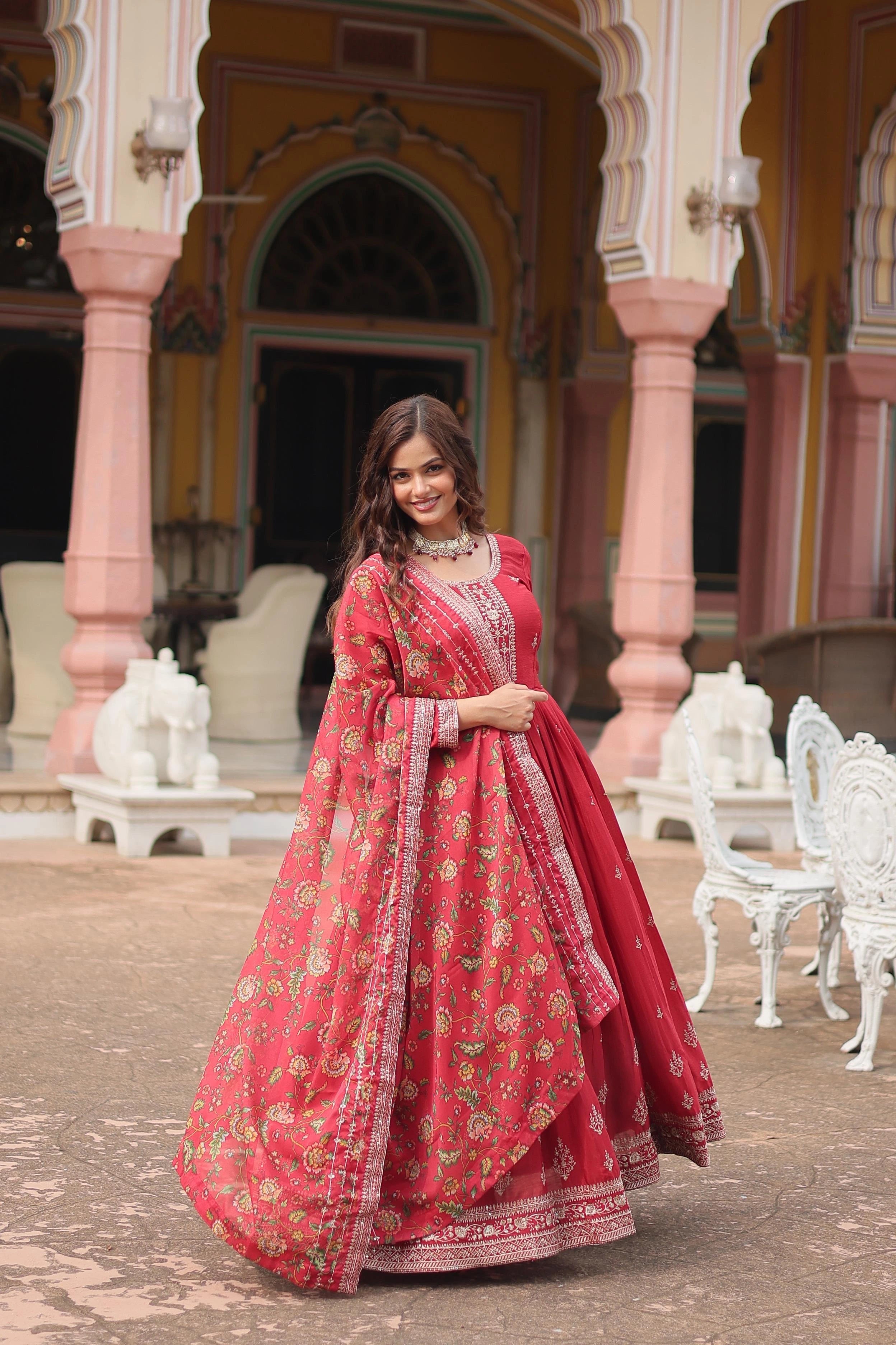 Woman in a red traditional outfit standing in front of an ornate building.