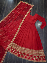 Red traditional outfit with gold embroidery on a dark background