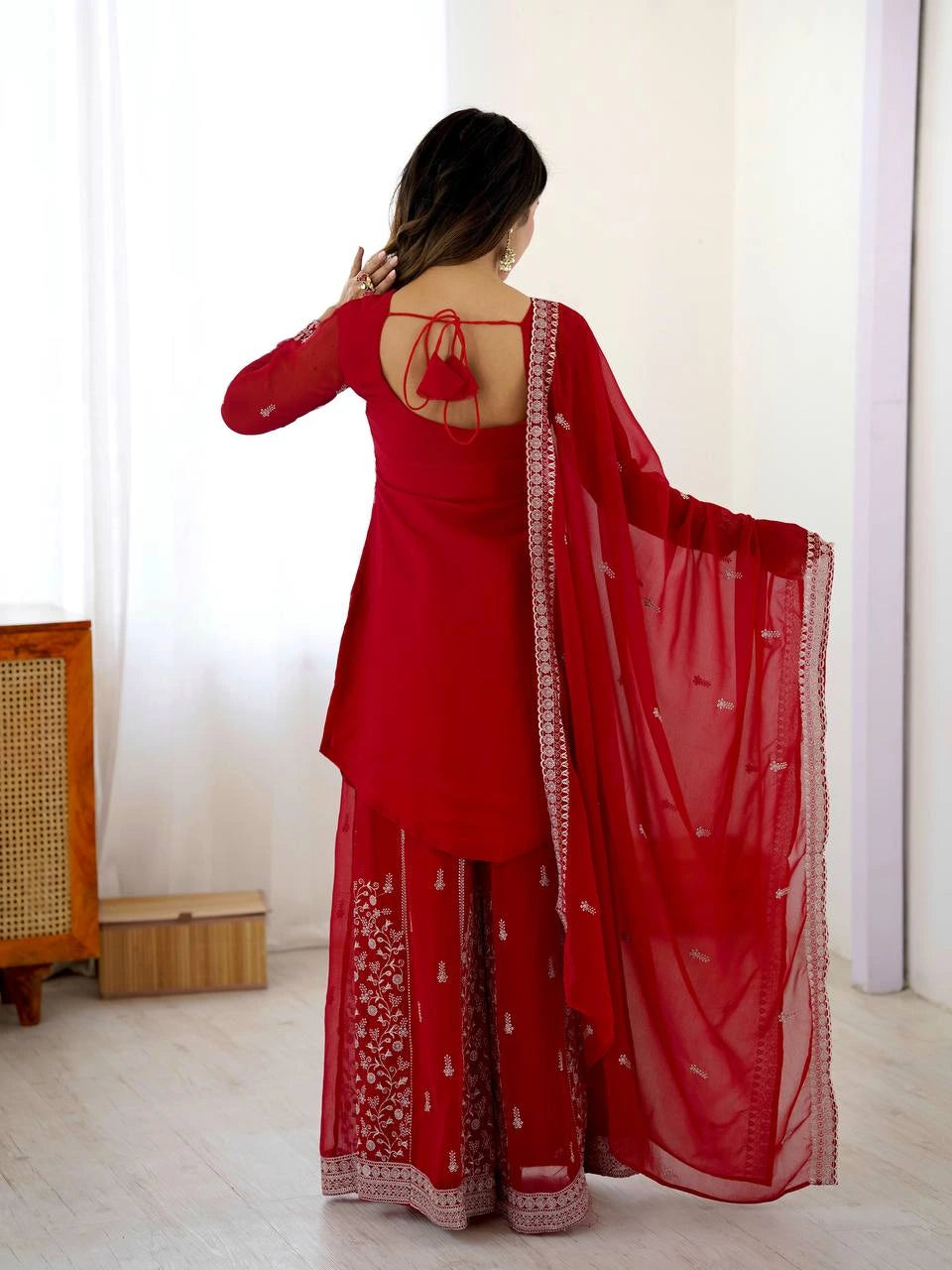Red traditional outfit with matching dupatta in a minimal indoor setting