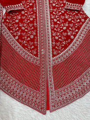 Red fabric with intricate white embroidery on a white background