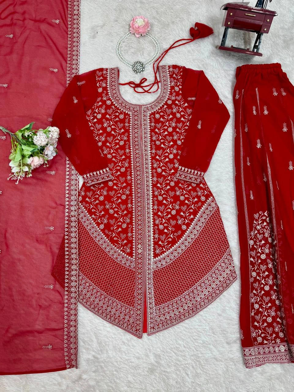 Red embroidered outfit with white patterns on a textured surface