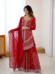 Woman wearing a red embroidered traditional outfit with a white background