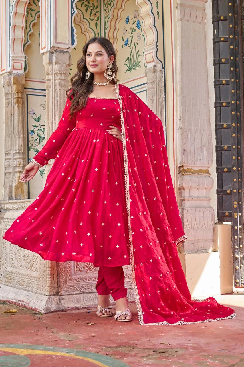 Woman in a red traditional outfit standing in front of an architectural background
