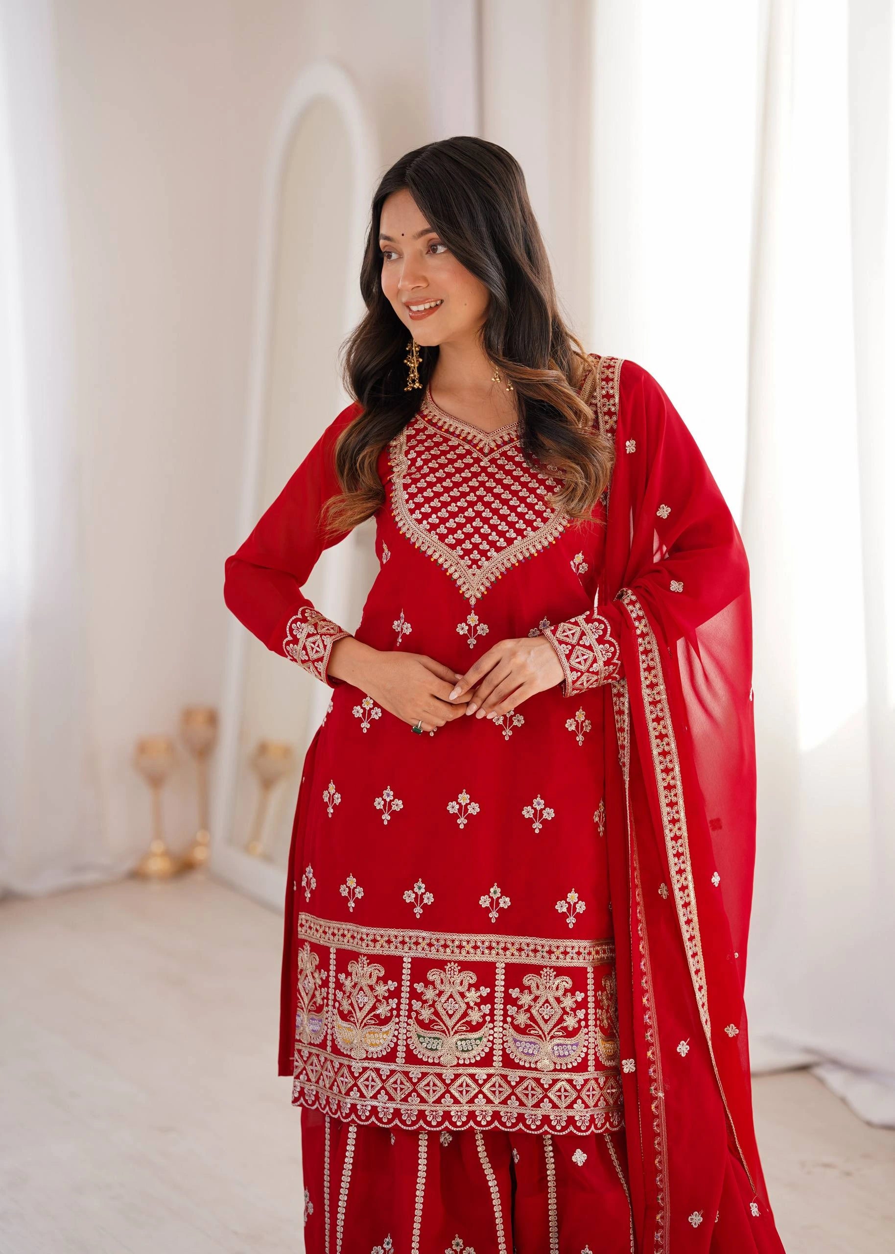 Woman wearing a red embroidered traditional outfit with a white background
