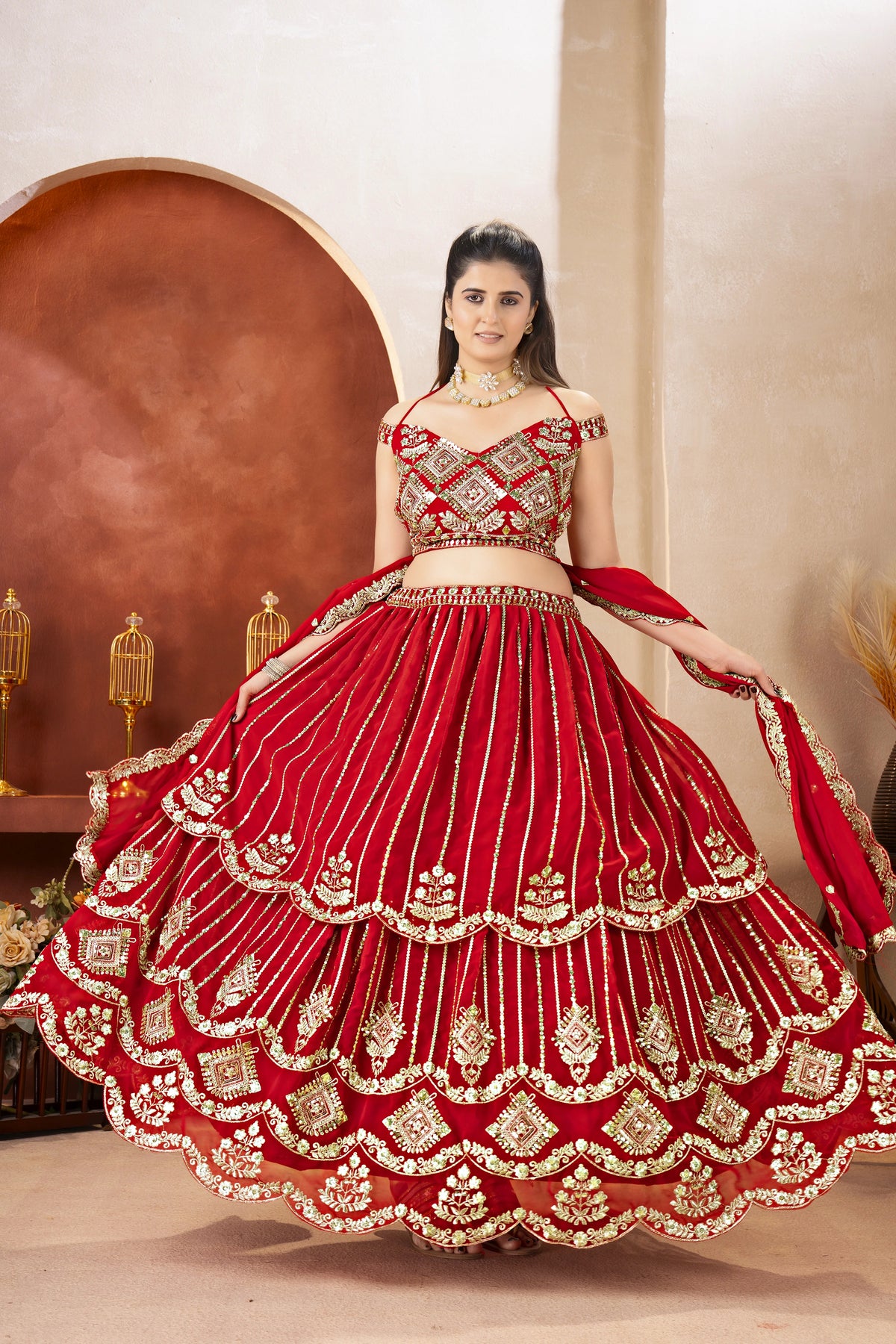 Woman in a red and gold traditional outfit with intricate designs.