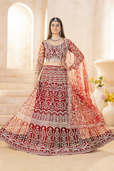 Woman in a red and white embroidered traditional outfit with a matching dupatta, standing indoors.