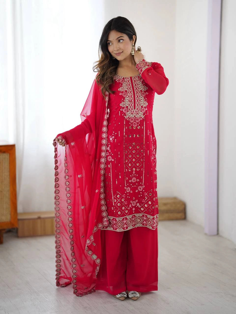 Woman wearing a red embroidered traditional outfit with a white background