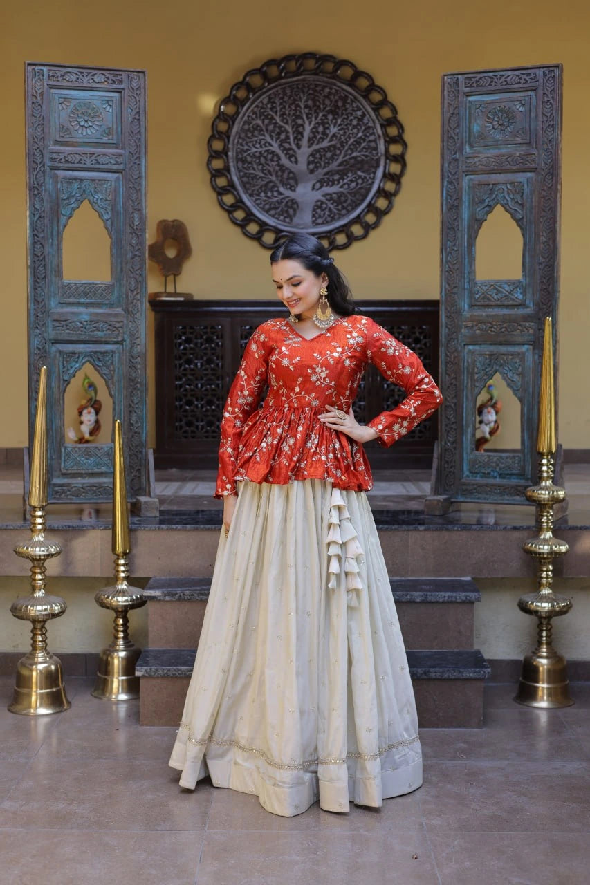 Woman in a red blouse and beige skirt standing in a decorated room with blue walls and gold candle holders.