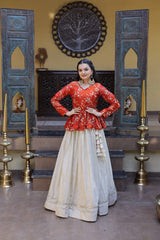 Woman in a red blouse and beige skirt standing in a decorated room with blue wooden panels and gold candle holders.