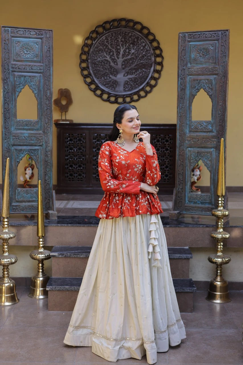 Woman in a red blouse and beige skirt standing in a decorated room with blue doors and gold candlesticks.
