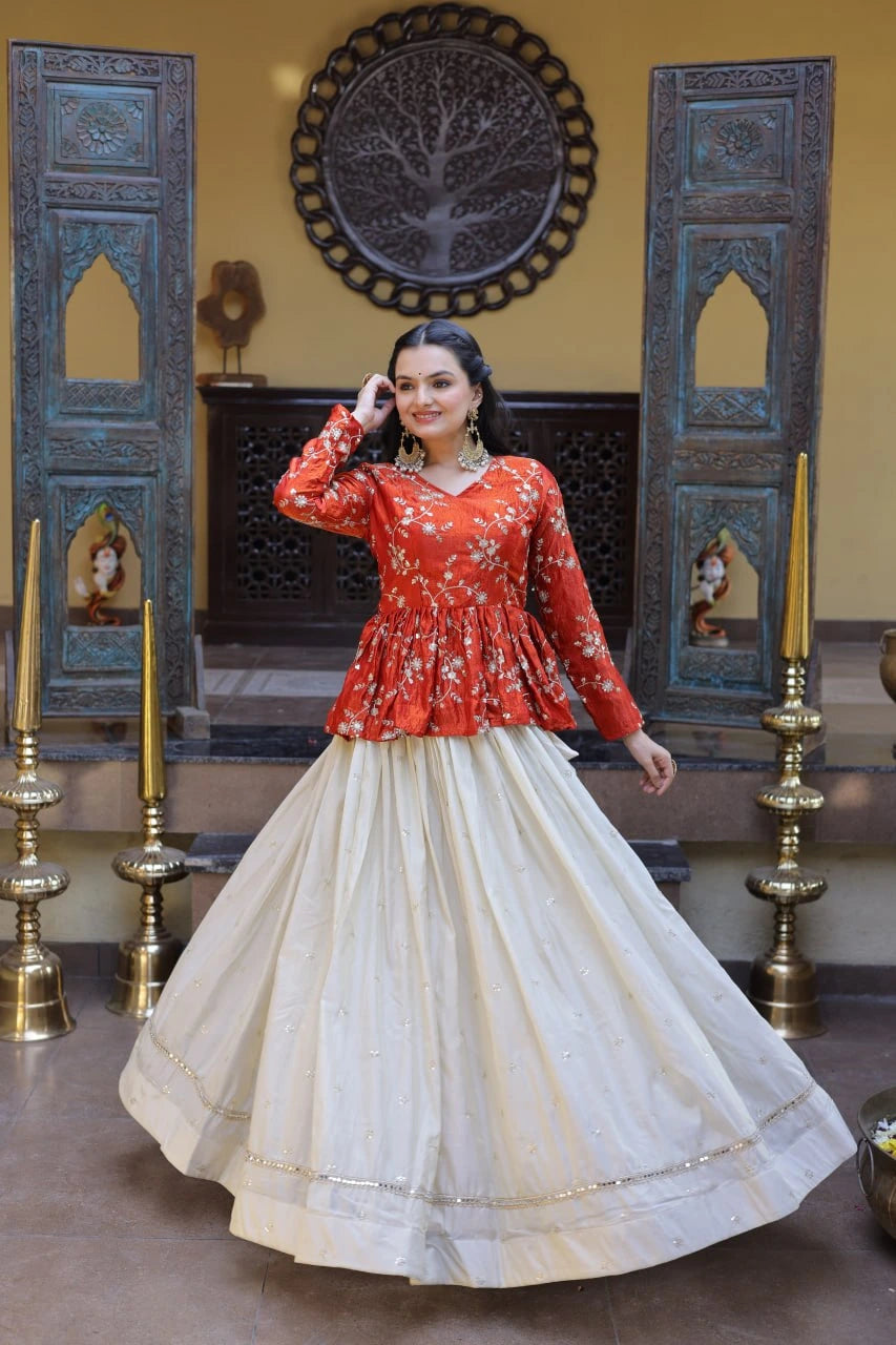 Woman in a red top and white skirt posing in a decorated room with blue wooden panels and gold candle holders.