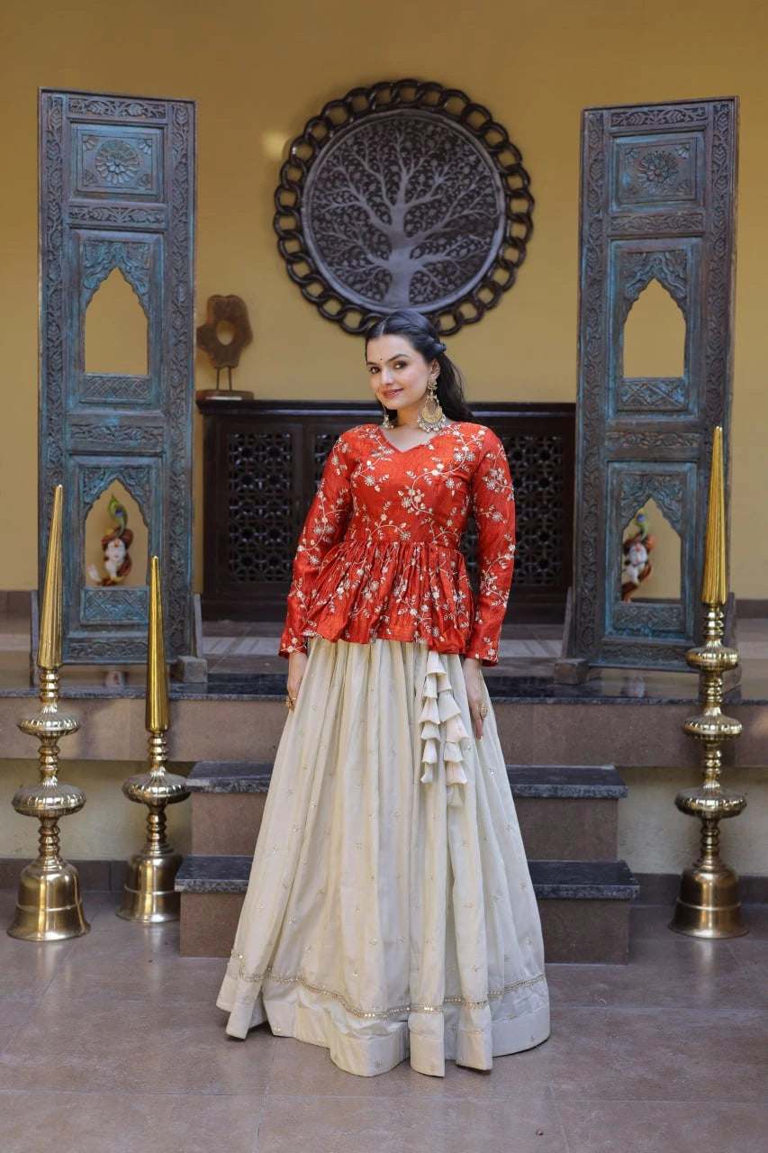 Woman in a red top and beige skirt standing in a decorated room with blue wooden panels and gold candle holders.