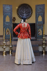 Person wearing a red blouse and beige skirt in a decorated room with blue panels and candles.