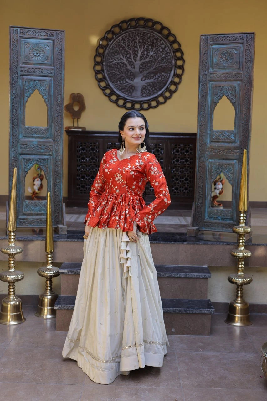 Woman in a red top and beige skirt standing in a decorated room with blue wooden panels and gold candle holders.