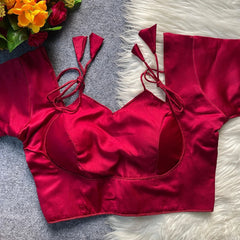 Red bikini top on a textured surface with flowers in the corner