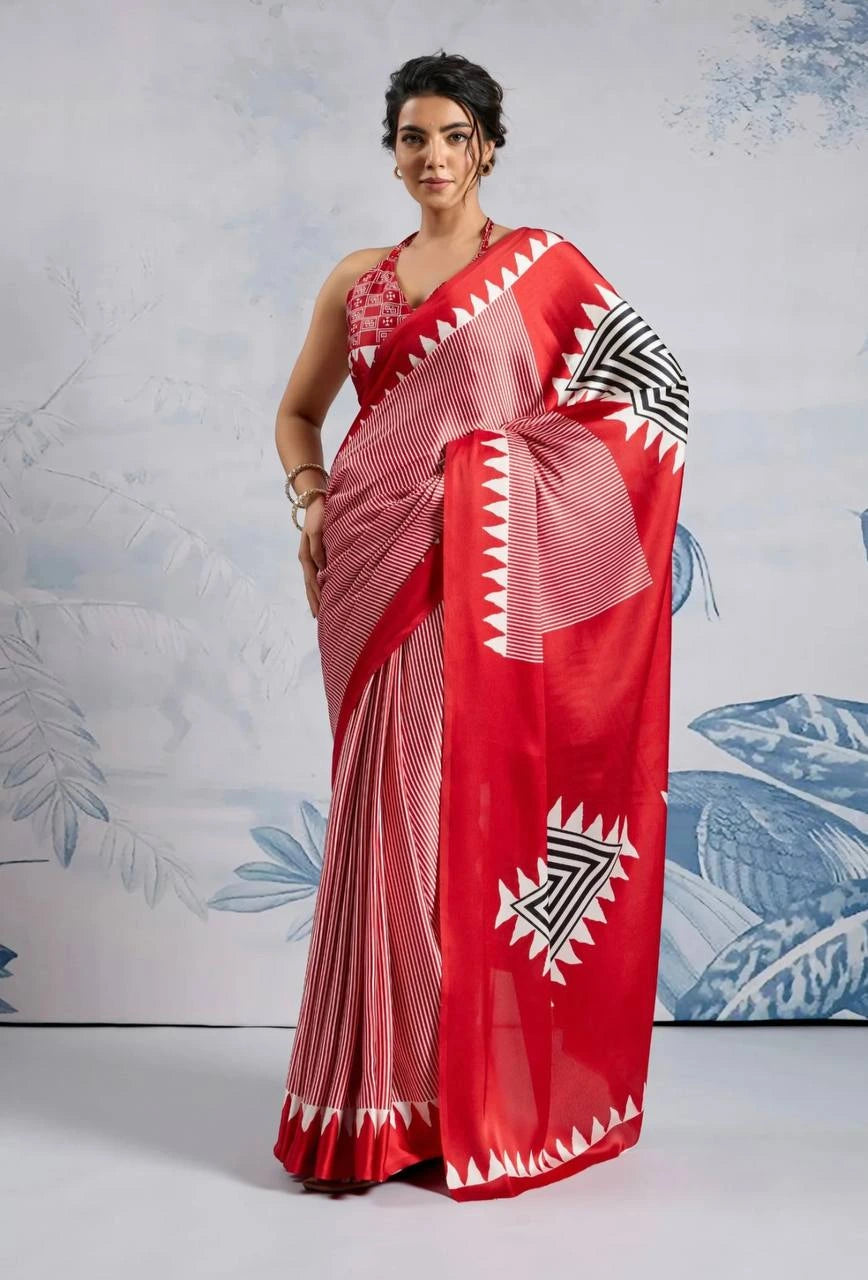 Woman wearing a red saree with white patterns against a light blue floral background