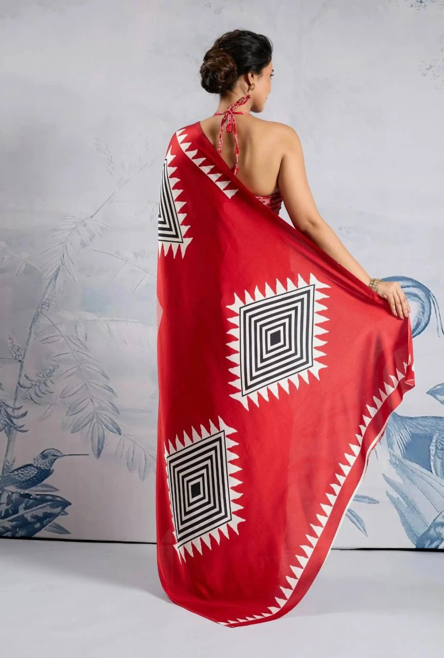 Woman wearing a red dress with black and white geometric patterns against a decorative background.